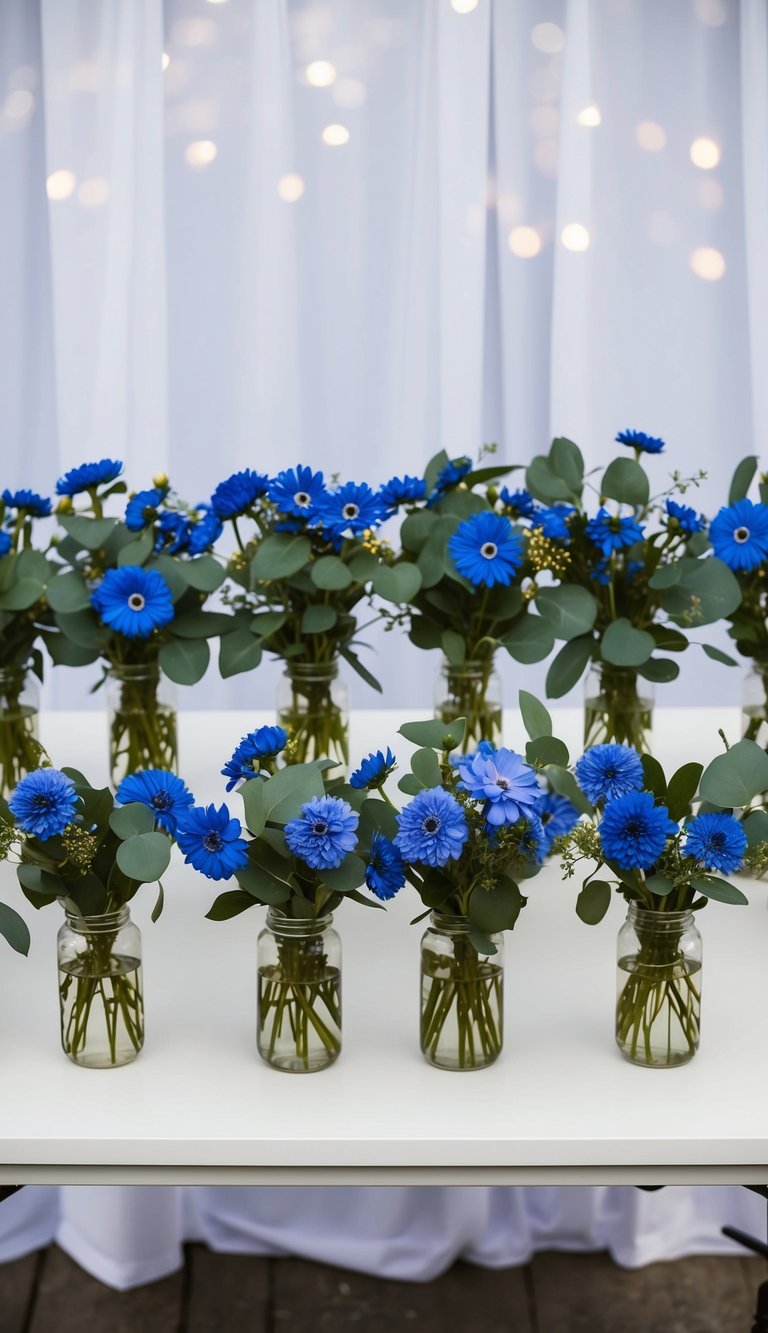 A table with 10 blue flower arrangements, featuring cornflowers and eucalyptus, set against a white backdrop